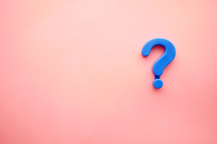 A salmon pink background with a cornflower blue question mark