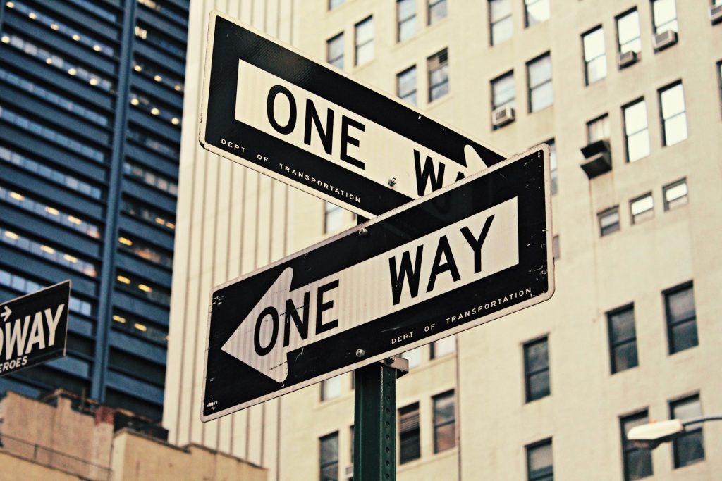 Signposts stating 'one way' pointing in different directions