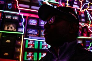 A person in a baseball cap in a light installation