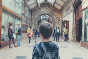 Child in a museum space, hearing about dinosaurs and insects.