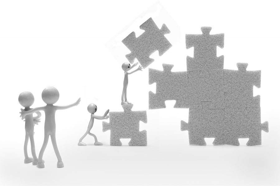 Stick people building a puzzle together