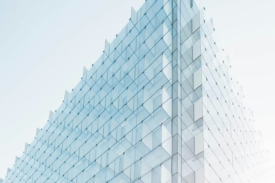 Photo of a triangular glass geometric structure against a pale blue sky